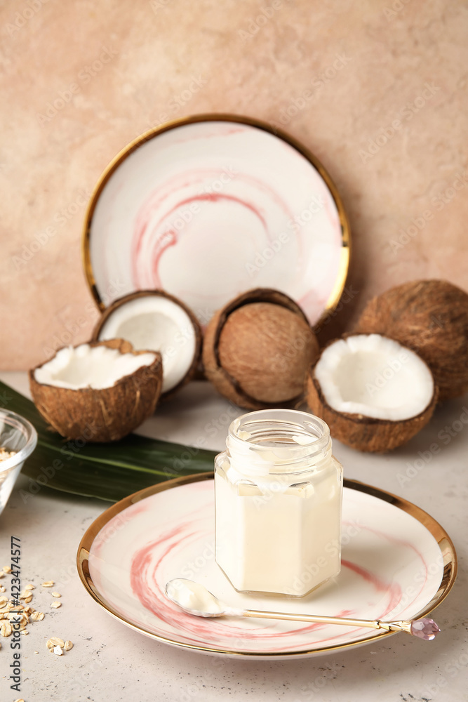 Jar with tasty coconut yogurt on table