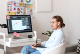 Fototapeta Panele - Young male designer working in office