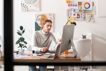 Poster - Young male designer working in office