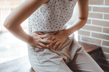 Young adult woman have stomach ill from period menstruation on day time.