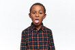 Portrait of nasty mischievous little black boy grimacing, making disgusting facial expression, sticking out tongue, acting naughty, teasing you, misbehaving. Childhood, upbringing and bad behavior