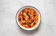 Vegetarian minestrone italian soup made with fresh vegetables, pasta and beans. Light gray background, top view