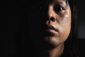 Sweaty face  And the tears of long-haired Asian men  On a black background  Expresses the personality of Psychopaths, Antisocial Personality Disorder.