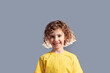 © oksix - Adorable 5 year kid in yellow t-shirt posing on gray