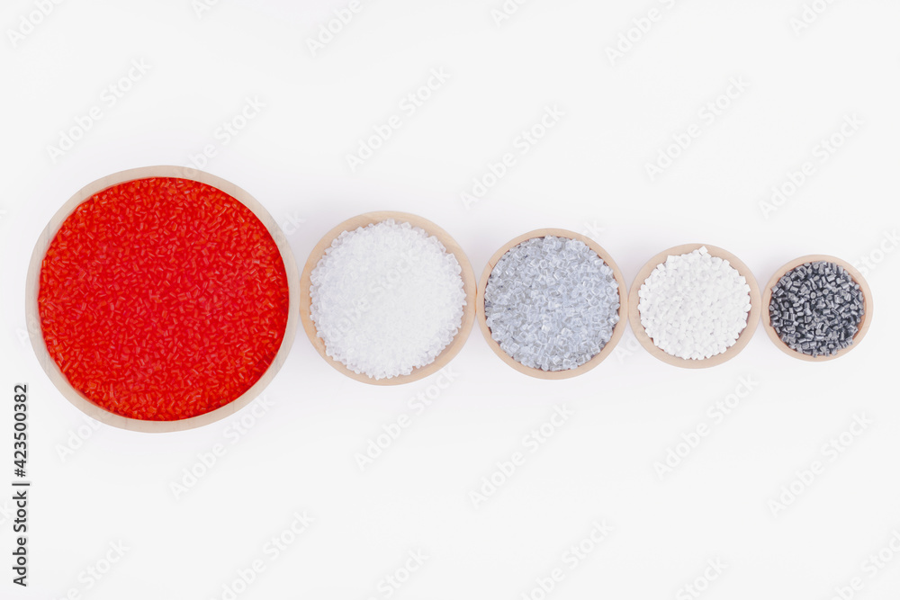 Polymer products of different colors in containers on a white ...