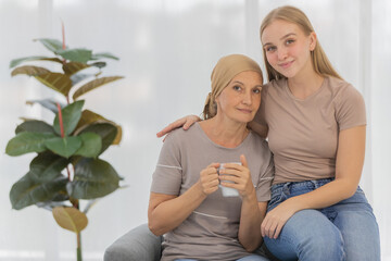 Wall Mural - A young and beautiful grateful daughter taking care and encourage her mother's cancer patient and fortifies her to fight during the chemotherapy