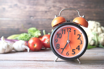 Wall Mural - alarm clock and fresh vegetables on table with copy space