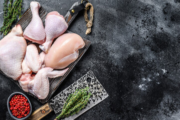 Wall Mural - Fresh raw chicken meat, wings, breast, thigh and drumsticks. Black background. Top view. Copy space