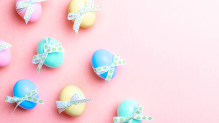 Wall Mural - Easter flat. Colorful egg with tape ribbon on pastel pink background in Happy Easter decoration. Spring holiday top view concept.