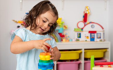 Smiling Caucasian girl playing with some toys in nursery