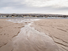Seawater Draining Out Of The Sand On Beach. North Devon, UK.