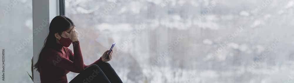 Depressed woman using phone alone at home during coronavirus pandemic panoramic banner. Anxiety, depression, grief mental heatlh concepts. - obrazy, fototapety, plakaty 
