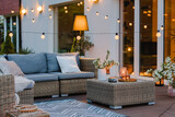 Fototapeta Panele - Summer evening on the terrace of beautiful suburban house with patio with wicker furniture and lights