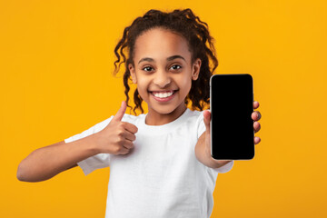 Black girl showing blank empty smartphone screen and thumbs up