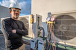 © spatesphoto - HVAC mechanic standing next to mini-split air conditioners with tools on it