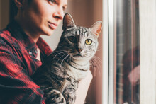 Young Woman At Home Holding Domestic Cat