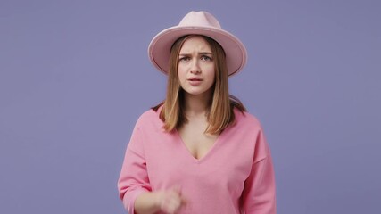 Wall Mural - Secret blonde young woman 20s in pink t-shirt hat posing isolated on violet purple background in studio. People lifestyle concept. Looking aside saying hush be quiet with finger on lips shhh gesture