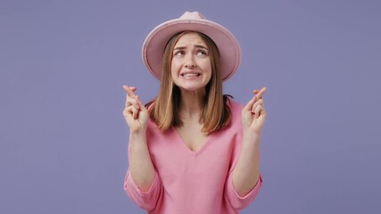 Wall Mural - Pleading young woman in pink t-shirt hat posing isolated on violet purple background studio. People lifestyle concept. Hold hands folded in prayer gesture keep fingers crossed begging about something