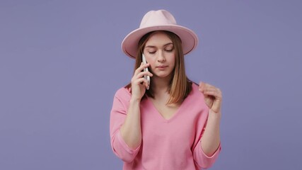 Wall Mural - Irritated blonde young woman 20s years old in pink t-shirt hat isolated on violet purple background studio. People lifestyle concept. Talking on mobile phone showing blah blah gesture ja jaja hands