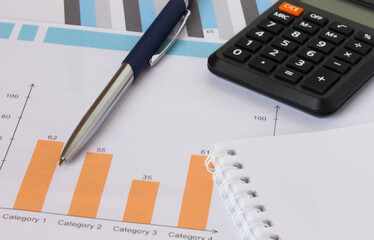 Profit bar chart, pen, notepad and calculator