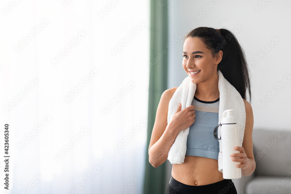 Pretty sporty woman having break after exercising at home - obrazy, fototapety, plakaty 