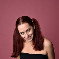 Canvas Print - Close up portrait of a red haired woman with expressive facial features on a pink studio background.