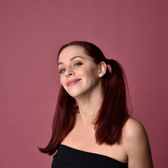 Sticker - Close up portrait of a red haired woman with expressive facial features on a pink studio background.