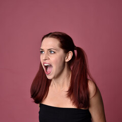 Sticker - Close up portrait of a red haired woman with expressive facial features on a pink studio background.