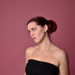 Sticker - Close up portrait of a red haired woman with expressive facial features on a pink studio background.