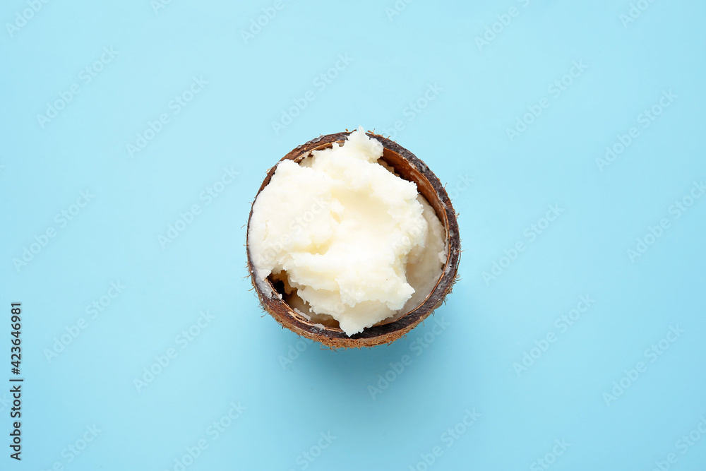Coconut oil in shell on color background - obrazy, fototapety, plakaty 