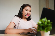 Close Up Young Asian Woman Call Center Talking On Microphone Headset To Assist And Consult Colleagues Or Customer At Home Office In Lockdown And Quarantine Time For Work From Home Concept