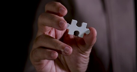 Poster - Slow Motion 4K Video close up businessman show jigsaw piece in hand. Concept for business strategy and marketing plan.