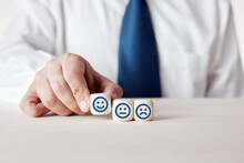 Hand Of A Businessman Selecting The Happy Face Icon On A Wooden Cube. Customer Evaluation And Satisfaction Rating