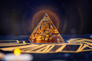 Poster - A glass pyramid with a Golden frog with magic aura. Tarot cards are scattered on the table. Close-up. Copy space. The concept of divination, magic and esotericism