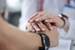 Doctor holding patient hands in clinic closeup