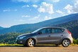 © Pellinni - mizhhirya, ukraine - AUG 08, 2020: car on the concrete parking on top of the mountain in morning light. travel countryside concept. beautiful nature scenery views in summer with clouds on the blue sky