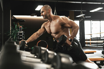 Poster - Bodybuilder doing one-arm dumbbell row during his workout in a gym