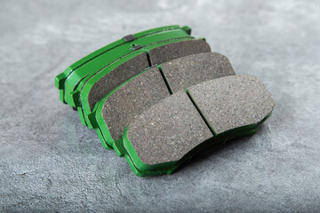 Wall Mural - a set of new green brake pads on a gray table