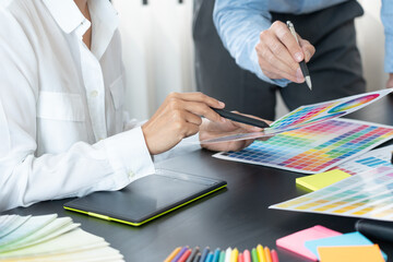 Poster - graphic designer or creative working together coloring using graphics tablet and a stylus at desk wi