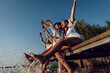 © Zoran Zeremski - Group of friends sitting on the edge of a pier having fun and enjoying a summer day at the lake.