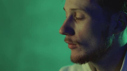 Portrait of a man on a neon light colorful background. Close-up.