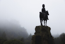 The Royal Scots Greys Monument, An Ominous Dark Presence And Equestrian Statue Over Princes Street Gardens On A Misty, Foggy Day In Edinburgh, Scotland.