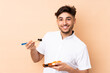 © luismolinero - Arabian man eating sushi isolated on beige background