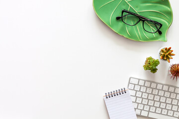 Wall Mural - White home desk with Monstera leaf and computer keyboard. Copy space. Top view. Office supplies. Home office.