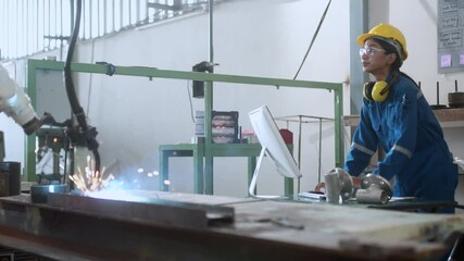 engineer cooperation male and female technician maintenance control relay robot arm system welding with tablet laptop to control quality operate process work heavy industry 4.0 manufacturing factory