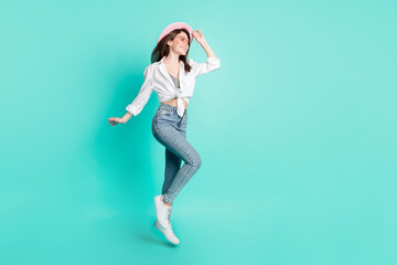 Sticker - Photo of cute adorable lady wear spectacles arm headwear jumping high looking empty space isolated turquoise color background