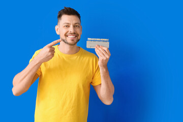 Poster - Man with teeth color chart on blue background