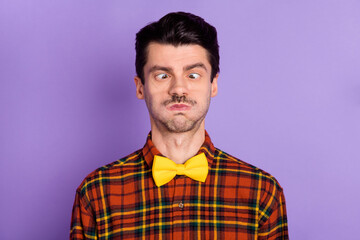 Sticker - Photo of funny childish young man dressed checkered shirt bloated cheeks looking nose isolated purple color background