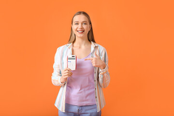 Canvas Print - Young woman with calculator on color background