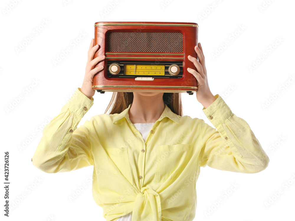Young woman with retro radio receiver on white background